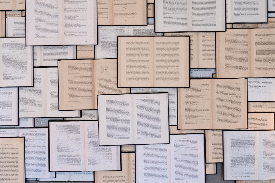 Aufgeschlagene Bücher übereinandergestapelt
