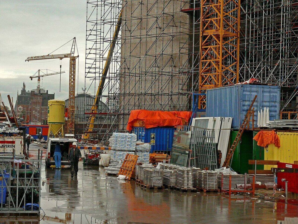 Baustelle mit Gerüst, Kranen, Containern und gestapeltem Material